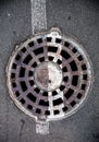 Manhole with metal cover in asphalt with white road marking line Royalty Free Stock Photo