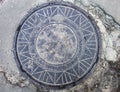 Manhole with metal cover in the cracked asphalt surface Royalty Free Stock Photo