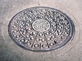 Manhole with metal cover in cracked asphalt surface