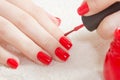 Manicure - Beautiful manicured woman`s nails with red nail polish on soft white towel. Royalty Free Stock Photo