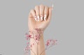 Manicure female hand with gypsophila flowers gel polish white long nails and red hearts design Royalty Free Stock Photo