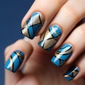 manicure with a geometric pattern in blue and gold with black lines.