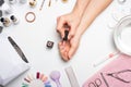 Manicure - the girl herself does, watching the nails with the help of a tool on a white background. Concept of beauty salons and n Royalty Free Stock Photo