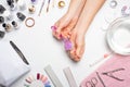 Manicure - the girl herself does, watching the nails with the help of a tool on a white background. Concept of beauty salons and n Royalty Free Stock Photo