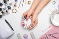 Manicure - the girl herself does, watching the nails with the help of a tool on a white background. Concept of beauty salons and n Royalty Free Stock Photo