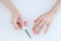 Manicure. Hands of a caucasian woman with nail file. White background Royalty Free Stock Photo