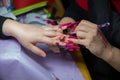 Woman in a nail salon receiving a manicure by a beautician . Manicure process in beautiful salon . Closeup of Woman applying nail Royalty Free Stock Photo