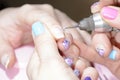 Manicure master cuts the cuticle on the client