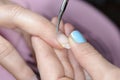 Manicure master cuts the cuticle on the client