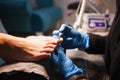 Pedicure master polishes nails with nail file drill before applying varnish side view Royalty Free Stock Photo