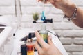 Manicure master table with tools for work. A girl holding a jar of cuticle oil with an electric nail file and nail polish in the Royalty Free Stock Photo