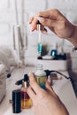 Manicure master table with tools for work. A girl holding a jar of cuticle oil with an electric nail file and nail polish in the Royalty Free Stock Photo
