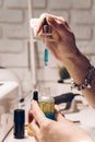 Manicure master table with tools for work. A girl holding a jar of cuticle oil with an electric nail file and nail polish in the Royalty Free Stock Photo