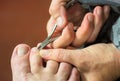 Manicure master trimming cuticles on woman toes with pedicure scissors, cutters. Royalty Free Stock Photo