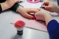 Manicure nail paint, Closeup shot of a woman in a nail salon receiving a manicure by a beautician Royalty Free Stock Photo