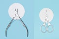 Manicure nippers and scissors on white cotton pad on blue background. Nails care equipment. Stainless steel nippers and scissors Royalty Free Stock Photo