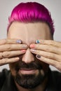 Manicure with a pattern on the fingers of a man, purple hair on the head of a guy. Hand nail care