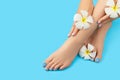 Manicure, pedicure beauty salon concept. Womans feet on blue background