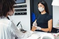 Manicure and pedicure salon, covid-19 concept. Asian girl in protective mask disinfects nails to client