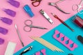 Manicure or pedicure tools scattered on a pink and blue background