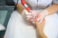 Manicure in process.Closeup shot of a woman in a nail salon receiving a manicure by a beautician with nail file. Woman getting Royalty Free Stock Photo