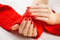 Manicure with a red knitted scarf