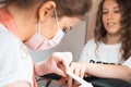 Manicure salon woman receiving a manicure by a beautician with nail file. Woman getting nail manicure. Professional Royalty Free Stock Photo