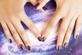 manicure stylish concept: woman fingers with nails purple glitter on nails like cosmos, universe background Royalty Free Stock Photo