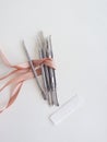 Manicure tools on a white background, there is space for text, top view, wrapped with pink ribbon, aesthetics. Beauty