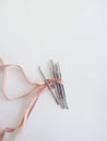 Manicure tools on white background, top view, space for text, wrapped with pink ribbon. Aesthetics. Beauty salon.