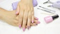 Manicure. Women`s hands with a beautiful manicure on a white background. Pink manicure, nail art, glitter Polish. Nude, pastel,