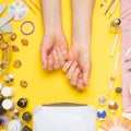 Manicure-work with nails, beauty care. Woman gets a manicure nails. Beautician puts nails to client, on yellow background Royalty Free Stock Photo