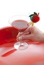 Manicured female hand holding red cocktail drink