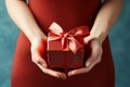 Manicured gesture Womans hands delicately hold a red gift