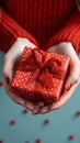 Manicured gesture Womans hands delicately hold a red gift