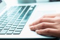 Manicured hand on blue laptop keyboard