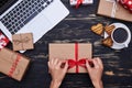 Manicured hands of female ties the ribbon bow tie on gift box Royalty Free Stock Photo