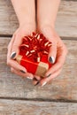 Manicured hands holding little gift box.