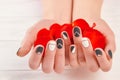 Manicured hands holding red petals. Royalty Free Stock Photo