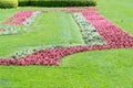 Manicured lawn with red flower beds in the park garden Royalty Free Stock Photo