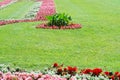 Manicured lawn with red flower beds in the park garden Royalty Free Stock Photo