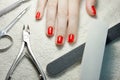 Manicured red nails with Nail implements on white towel