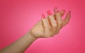 Manicured woman`s nails with pink nailart with flowers.