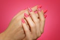 Manicured woman`s nails with pink nailart with flowers.