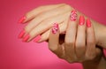 Manicured woman`s nails with pink nailart with flowers.