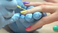 Manicurist accurately applying nail polish.