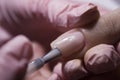 The manicurist applies a layer of gel Polish to the client`s nail. Applying pink nail Polish with a brush.