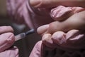 The manicurist applies a layer of gel Polish to the client`s nail. Applying pink nail Polish with a brush.