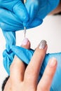 Manicurist applies a layer of gel polish to the clientÃ¢â¬â¢s nail. Brush pink nail polish