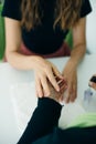 Manicurist applying cuticle softener or clear nail varnish to the fingernails of a lady client in a spa or beauty salon Royalty Free Stock Photo